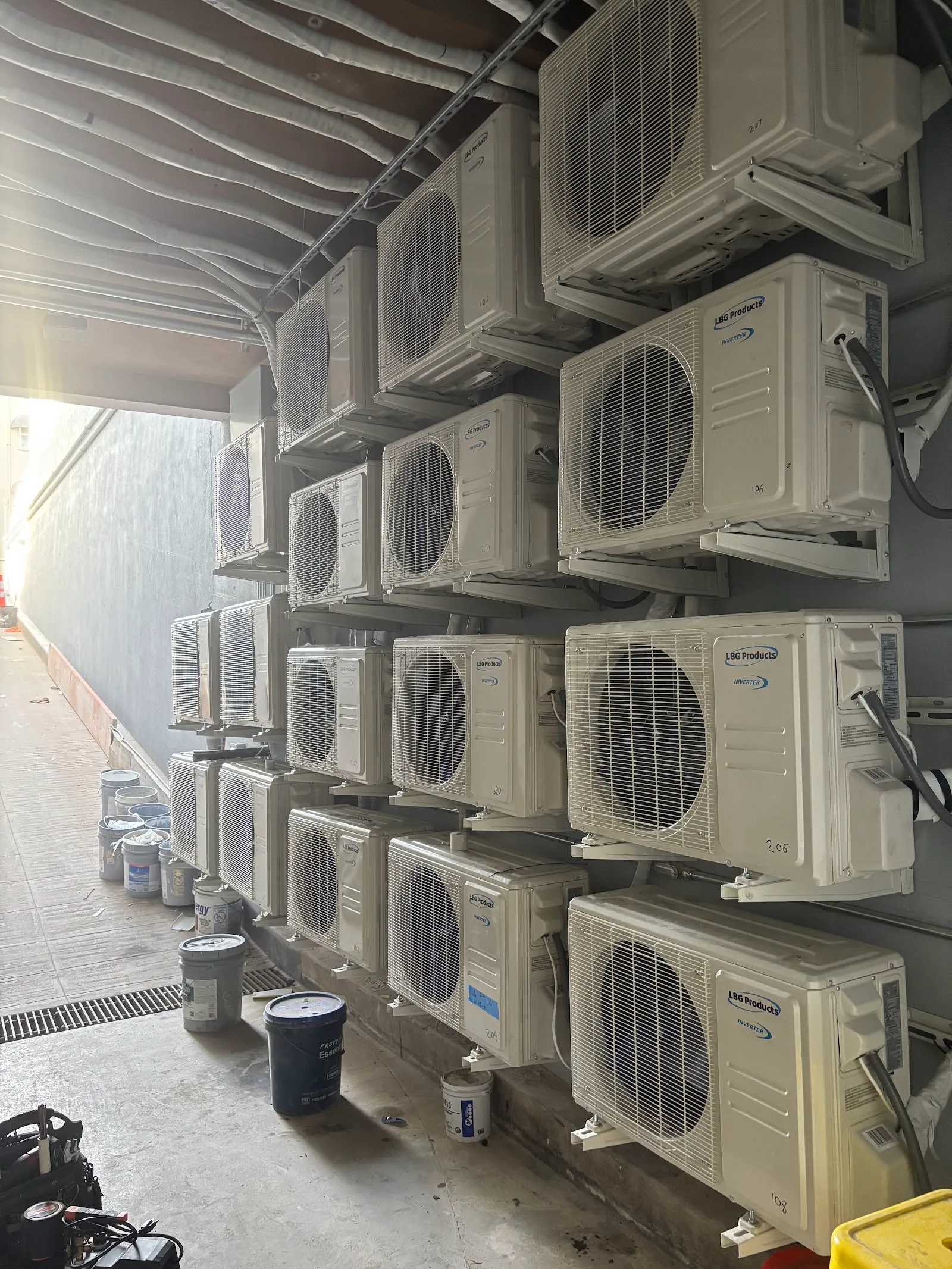A wall of mini-split outdoor units installed on brackets
