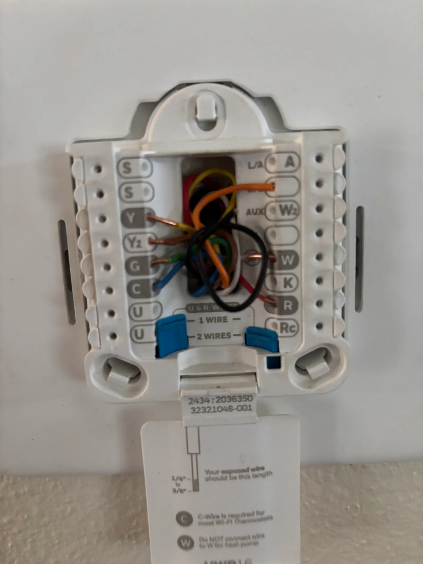 A thermostat base plate with labelled wiring